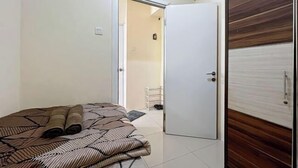 Un dormitorio con cama, una puerta y un armario.