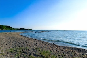 A beach with a sandy shore and calm water.