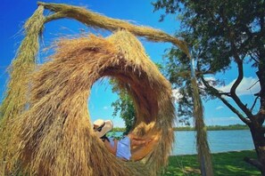 A hammock suspended from a tree branch, with a person reclining inside. - Moly Resort (Kampot)