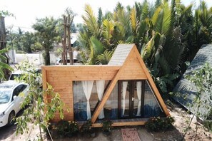 A small, triangular wooden structure with large windows, surrounded by greenery. - Moly Resort (Kampot)