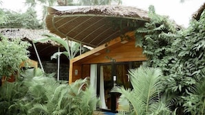 A wooden structure with a thatched roof surrounded by dense tropical foliage. - Moly Resort (Kampot)