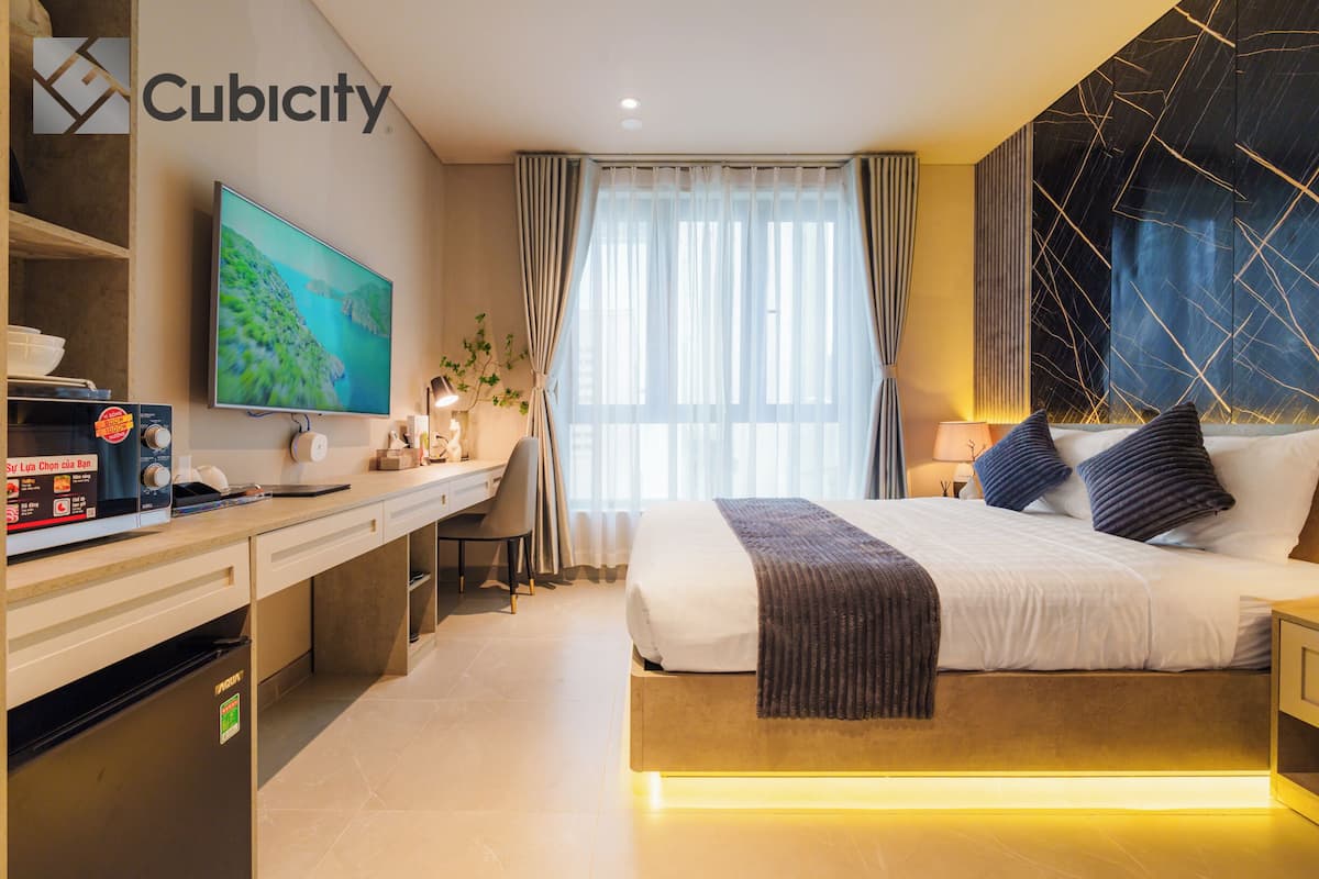 Ein modernes Hotelzimmer mit Bett, Schreibtisch und Fernseher.