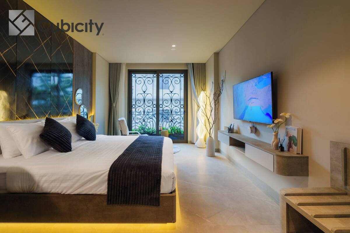 Ein modernes Schlafzimmer mit einem großen Bett, einem Fernseher und einem Balkon mit schmiedeeisernen Gittertüren.
