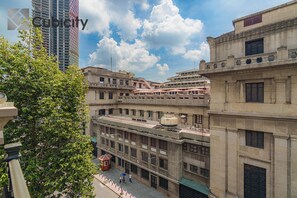 A multi-story building with a mix of architectural styles, including a prominent red and white striped tower. - Cubicity Wall Street House (Ho Chi Minh City)