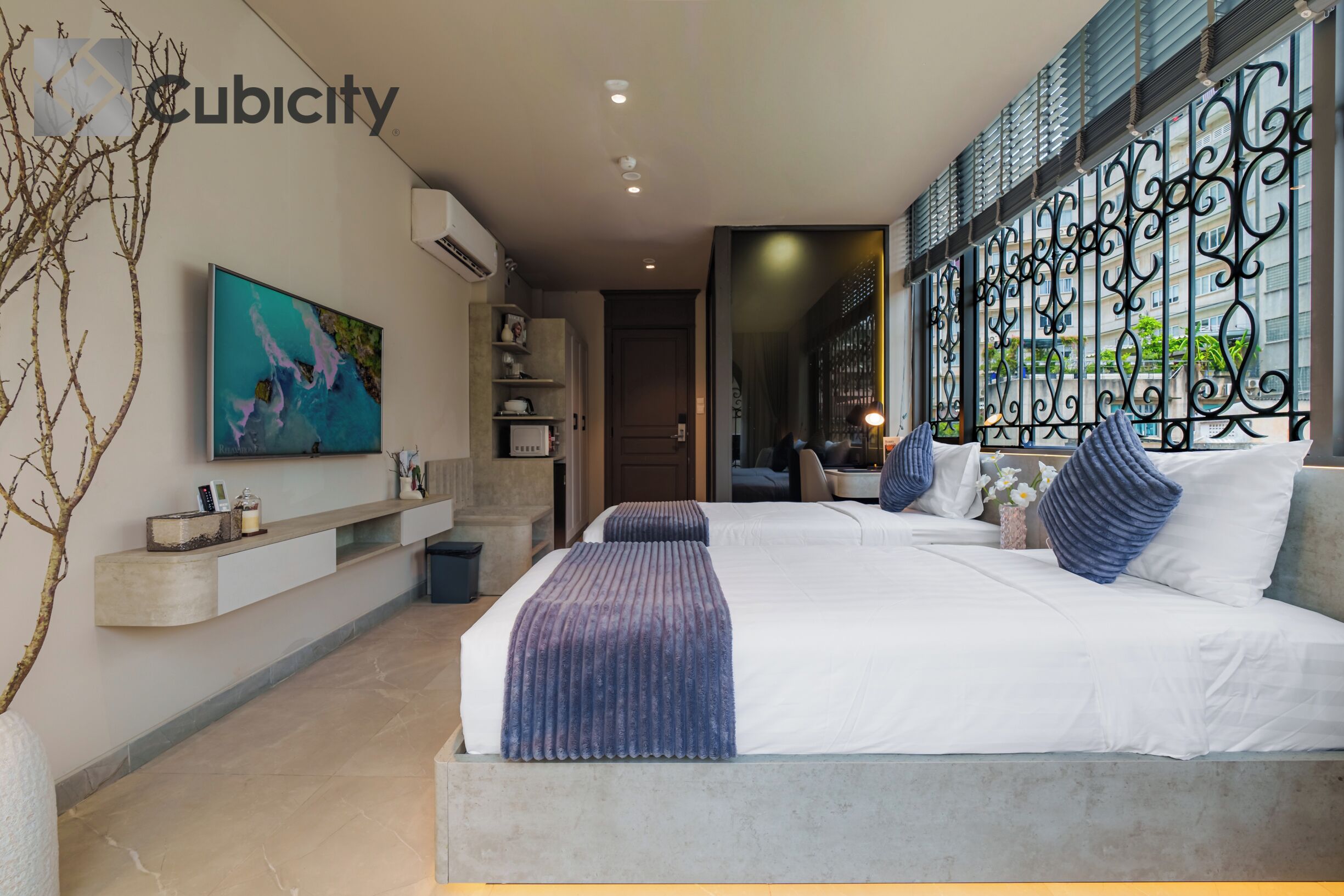 A modern bedroom with a large bed, a TV mounted on the wall, and a decorative iron gate.