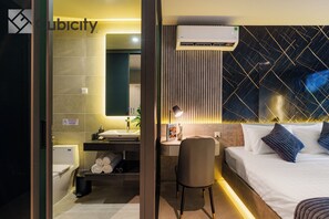 Ein modernes Hotelzimmer mit Bad, Schreibtisch und Bett.