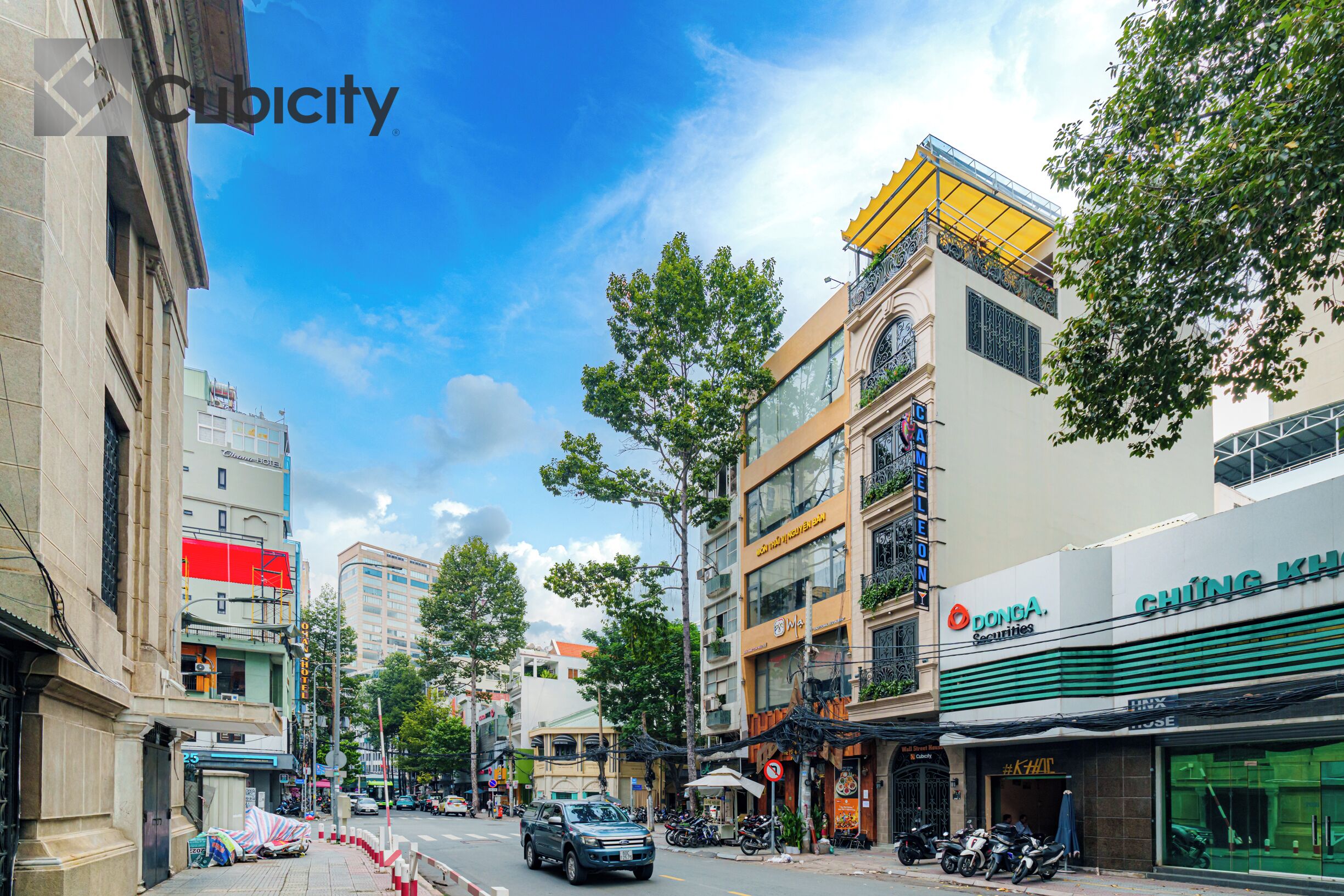 A street view with buildings, a car, and a motorcycle.