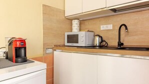 A compact kitchenette with a microwave, coffee maker, and a sink. - Vintage apartments in the center of Florence (Florence)