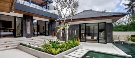 A modern house with a swimming pool, outdoor seating, and a well-maintained garden.