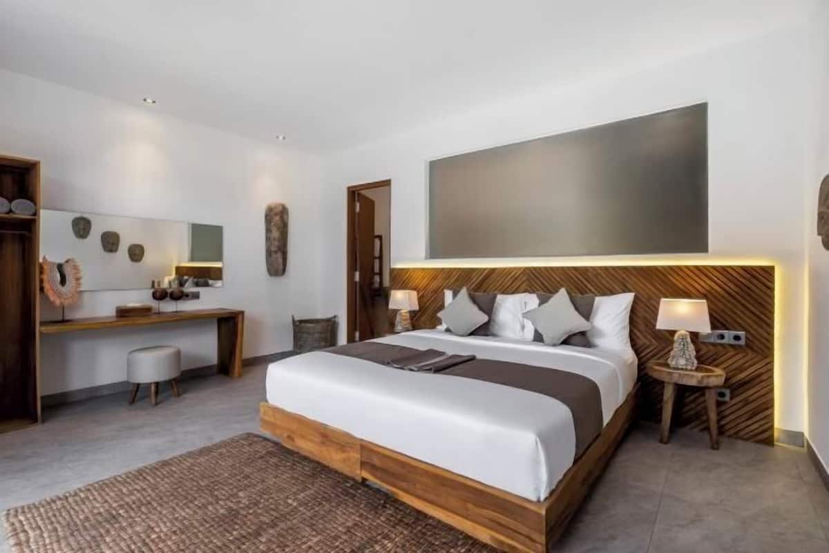 Ein modernes Schlafzimmer mit einem großen Bett, Nachttischen, einem Schreibtisch und einem großen abstrakten Gemälde an der Wand.