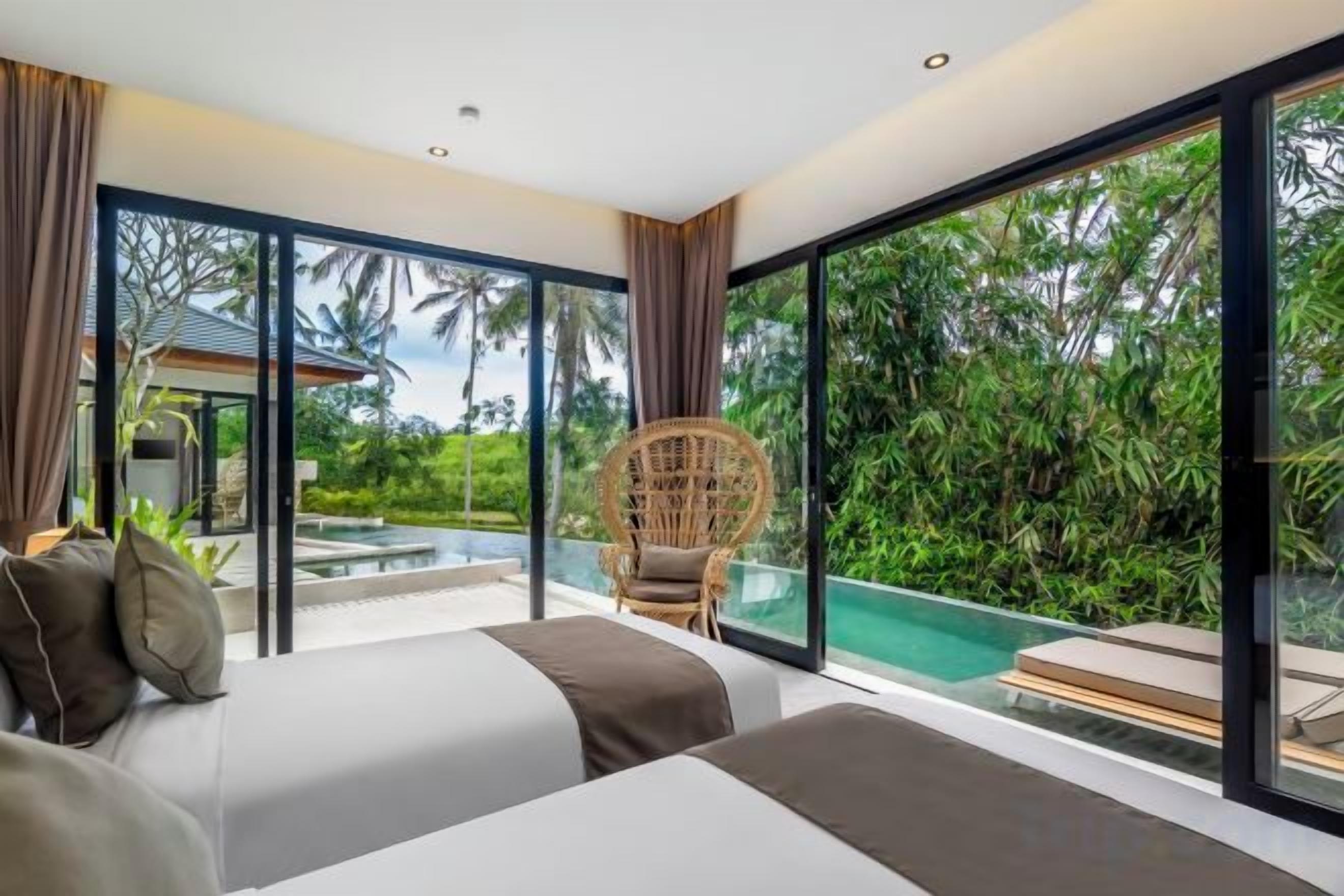 Une chambre avec deux lits, une grande fenêtre et une vue sur une piscine.