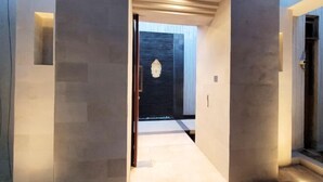 A modern entrance with a dark wooden door and a light-colored interior.