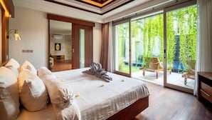 A spacious bedroom with a large bed, a wooden ceiling, and a sliding glass door leading to a garden.