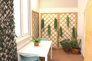 A small dining area with a white table, two chairs, and potted plants. - NEW, CENTRAL NEAR BEACH AND SEA by www.SanSebastianApartments.es (San Sebastian)