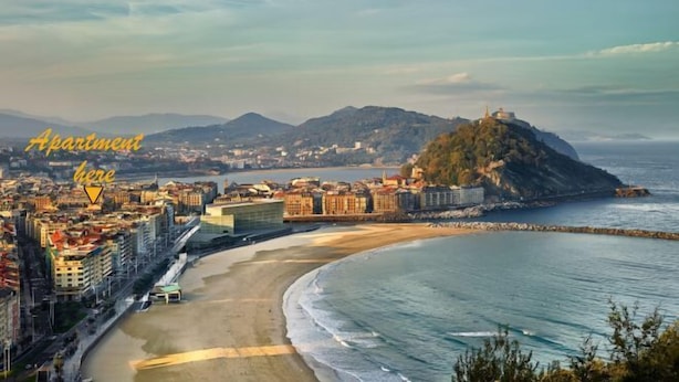 A coastal cityscape with a prominent hill, a beach, and a view of the sea. - NEW, CENTRAL NEAR BEACH AND SEA by www.SanSebastianApartments.es (San Sebastian)