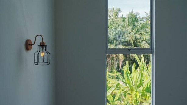 Um quarto com janela vista para um jardim exuberante.