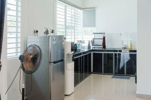 A kitchen with a refrigerator, microwave, and sink. - Secret Garden Homestay (Kuala Selangor)
