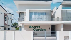 Um edifício moderno de dois andares com uma placa que diz 'Secret Garden'.