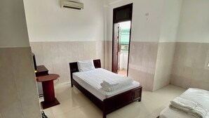 A hotel room with a bed, a small table, and a chair. - OYO 1296 Phu Loc Xuan Hotel Danang (Da Nang)