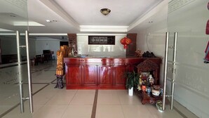 A reception area with a wooden counter, a decorative altar, and a red lantern. - OYO 1296 Phu Loc Xuan Hotel Danang (Da Nang)