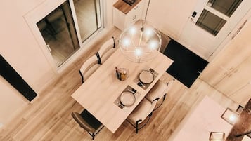 Een eetruimte met een houten tafel, stoelen en een kroonluchter.