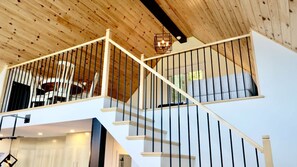 A staircase with a wooden ceiling and a modern light fixture. - Spa, Sauna, Lake and Pool table | The Dorchester (Saint-Prosper)