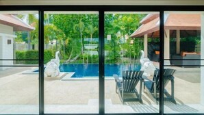 A modern hotel room with a large glass door leading to a pool area. - Lotus Pool Villa Your Own Slice Of Island Paradise (Phuket)