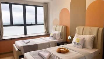 Et hotelværelse med to senge, havudsigt og moderne design.