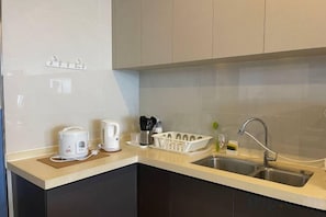 A kitchen with a sink, countertop, and cabinets.