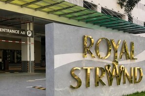 L’entrée d’un immeuble, avec une enseigne sur laquelle on peut lire : « ROYAL STRWIND ».
