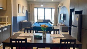 Una cocina moderna con comedor, mesa de billar y un amplio ventanal.
