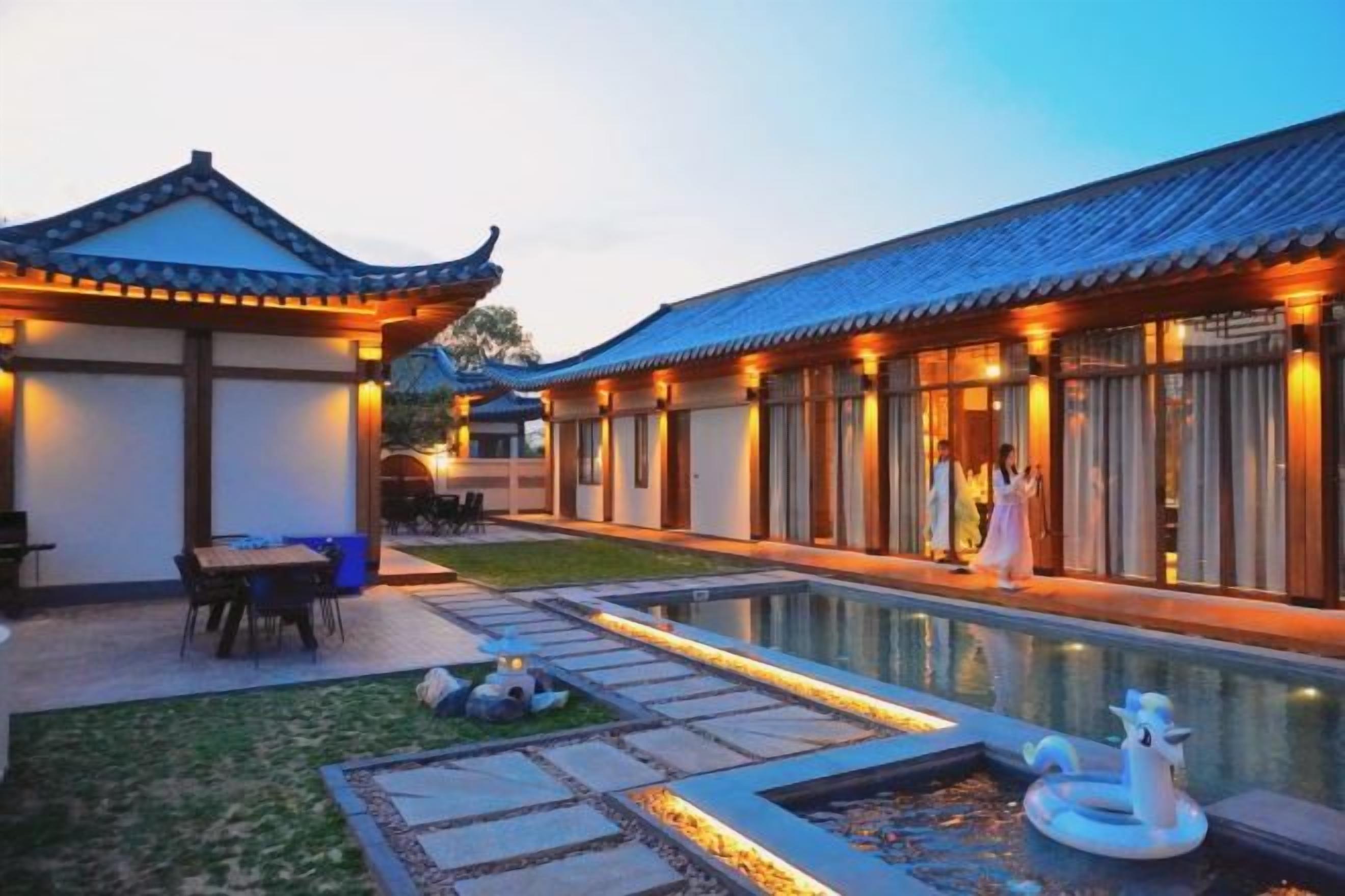 A traditional-style building with a courtyard, a pool, and a dining area.