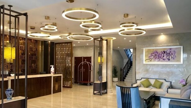 A modern lobby with a reception desk, seating area, and a staircase. - Hotel l'Orchidee Owendo (Libreville)