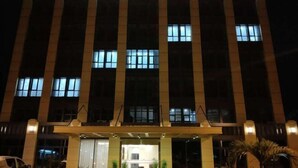 Een hotel genaamd HOTEL L'ORCHIDEE, met een moderne gevel en verlichte signage.
