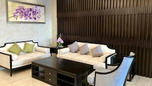A modern living room with two white sofas, a dark coffee table, and a wall-mounted artwork. - Hotel l'Orchidee Owendo (Libreville)