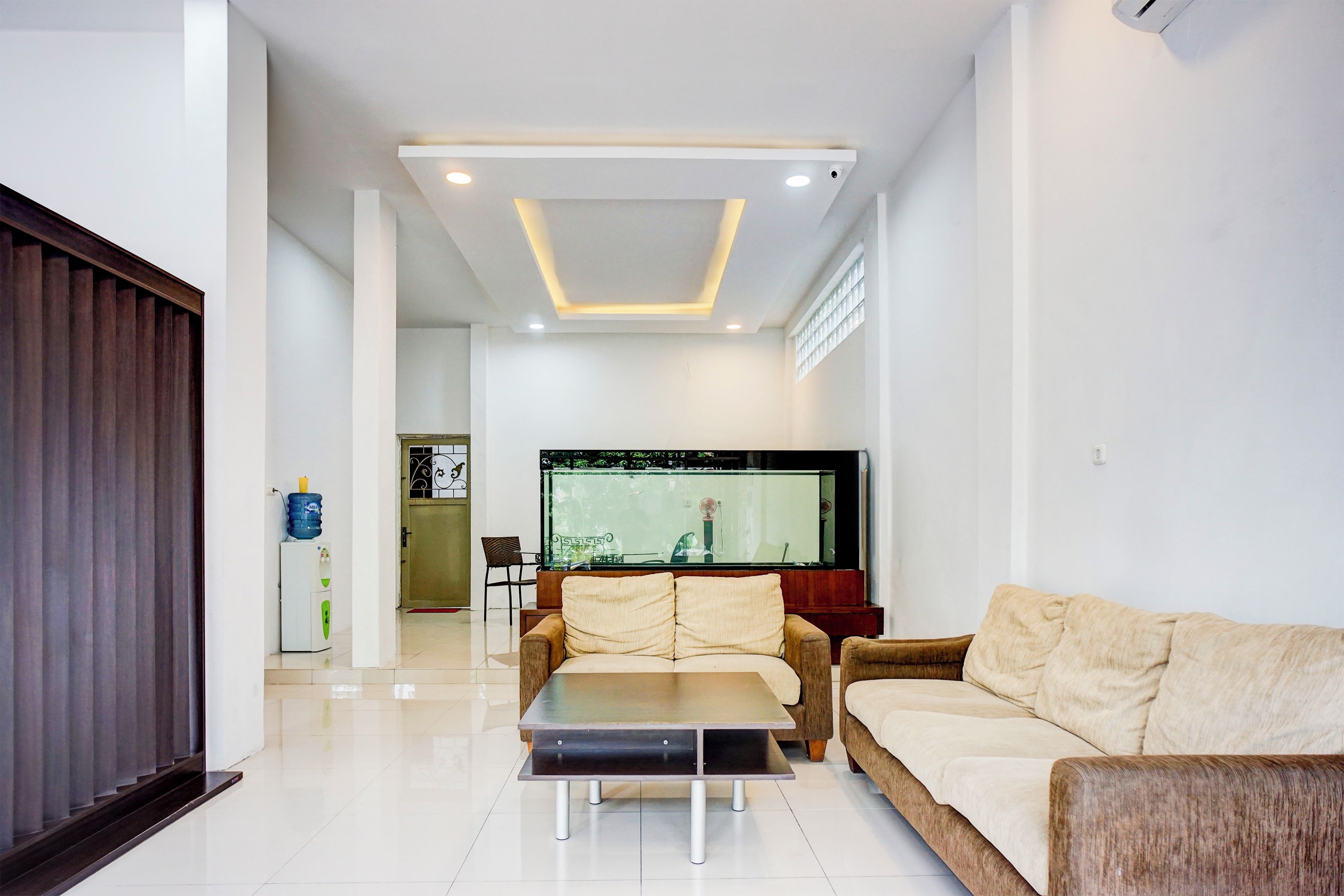 A modern living room with a sofa, a coffee table, and a TV.