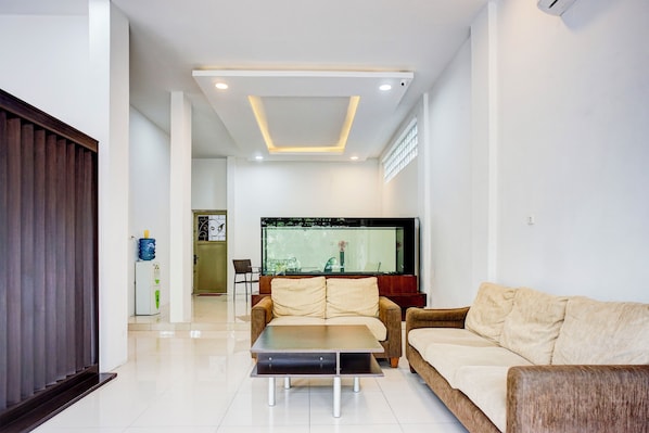 A modern living room with a sofa, a coffee table, and a TV. - Collection O Almasarra Resid Near Ring Rd Medan (Medan)