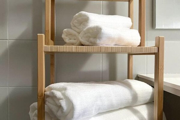 A wooden shelf with two white towels stacked on it. - Venice Home free parking (Venice)