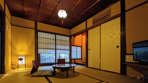 A traditional Japanese room with tatami flooring, a low table, and sliding doors. - Kyomachiya Hoshiya (Kyoto)