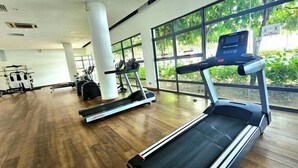 Ein Fitnessraum mit Laufbändern, Fahrrädern und Rudergeräten.