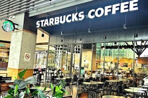 A Starbucks Coffee with outdoor seating and a view of the city. - The Loft Imago KK Time Square - 4 Bedrooms/ 10 PAX (Kota Kinabalu)