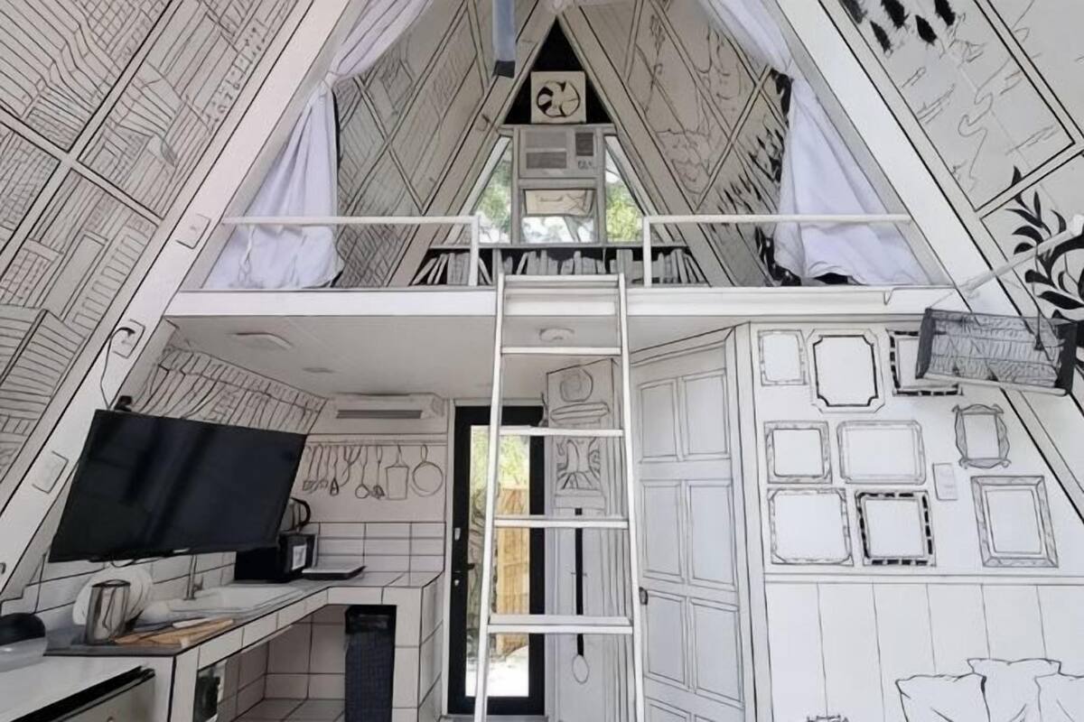 A loft-style bedroom with a desk, computer, and ladder to the upper bunk.