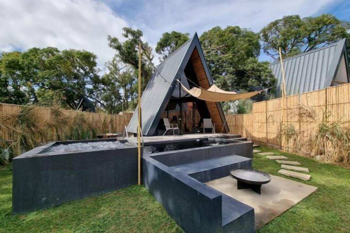 A modern outdoor pool area with geometric shapes and a wooden deck.