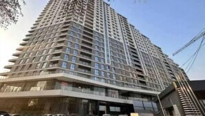 Un edifici alt amb múltiples pisos, grans finestres i balcons.