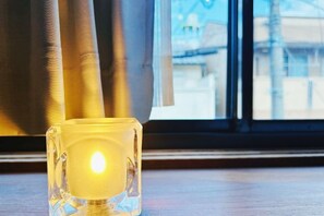A lit candle in a clear glass holder on a windowsill. - Rakuyado kyotofushimi II (Kyoto)