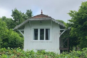 Un pequeño edificio de una sola planta con techo a dos aguas y una ventana.