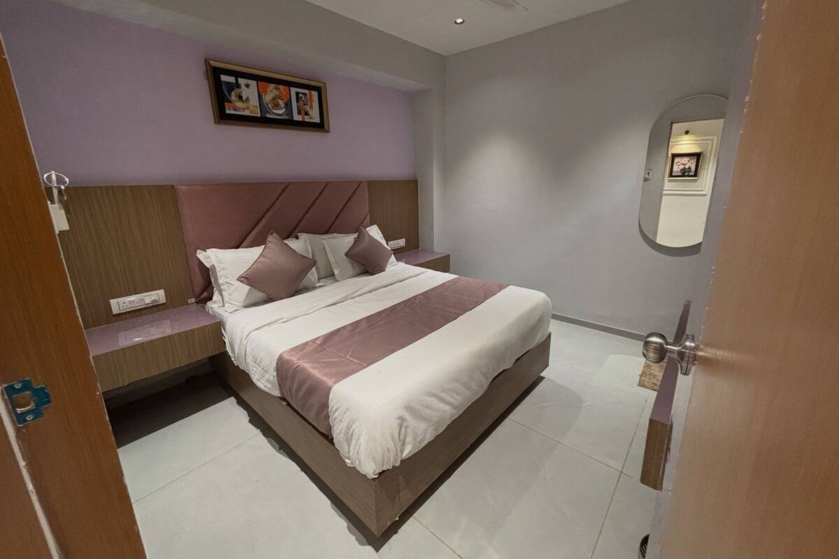 A modern bedroom with a bed, a headboard, a bedside table, and a wall-mounted artwork.