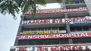 A multi-story building with various establishments including a hospital, a hotel, and a store. - Hotel Prenix Sky- Gota (Ahmedabad)