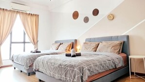 Une chambre avec deux lits, un ventilateur de plafond et une grande fenêtre avec des rideaux.