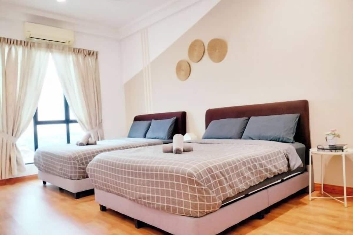 Een slaapkamer met twee bedden, een klein nachtkastje, een wandairconditioner en een raam met gordijnen.
